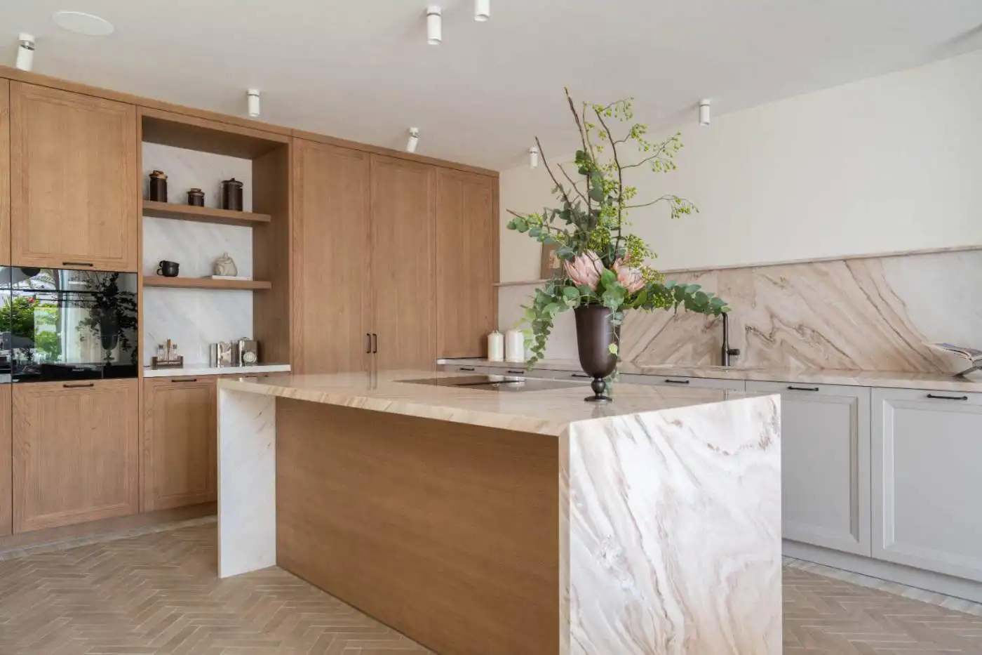 Bright, contemporary kitchen featuring wooden cabinetry and a marble-topped island, perfect for styl.