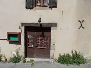 Traditional wooden door with decorative glass panels in a rustic village setting.