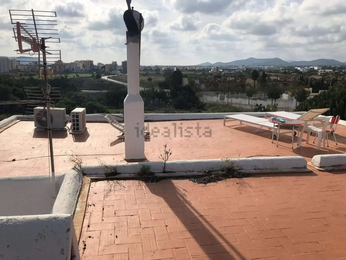 Rooftop terrace of villa estate with outdoor seating and city views in Playa Den Bossa, Ibiza, Spain.