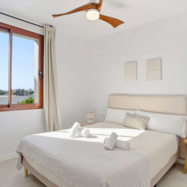 Elegant bedroom with large window and modern decor in Cancelada, Estepona.