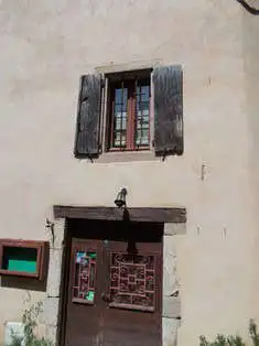 Beautiful view of a rustic French estate featuring a window with shutters and a decorative door.