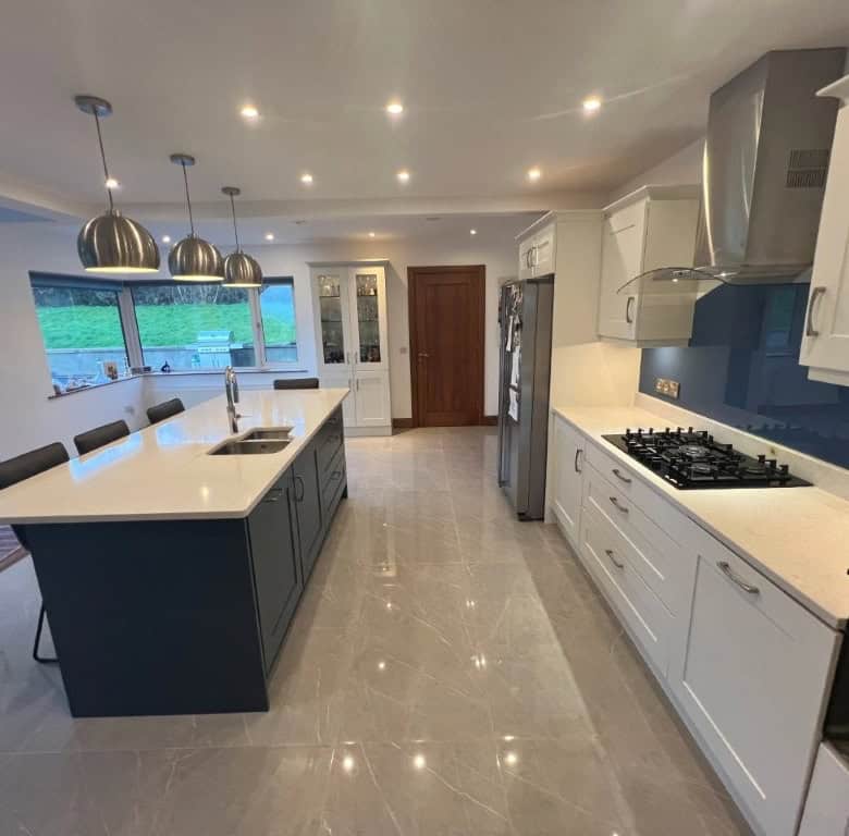 Contemporary kitchen featuring white cabinets, a large island, and modern appliances.