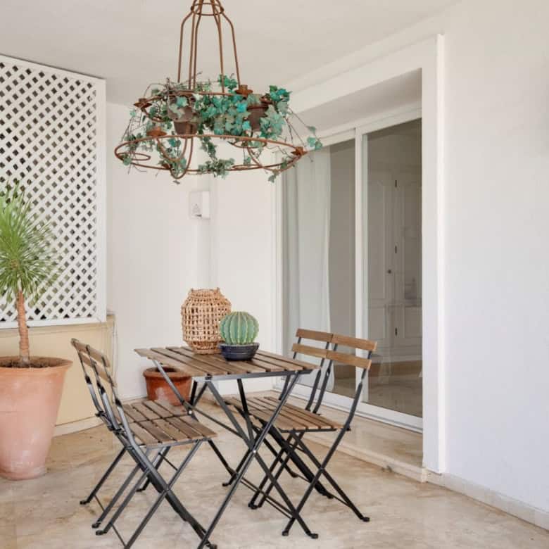 Balcony with outdoor seating and lush plant, perfect for relaxing and enjoying garden views.