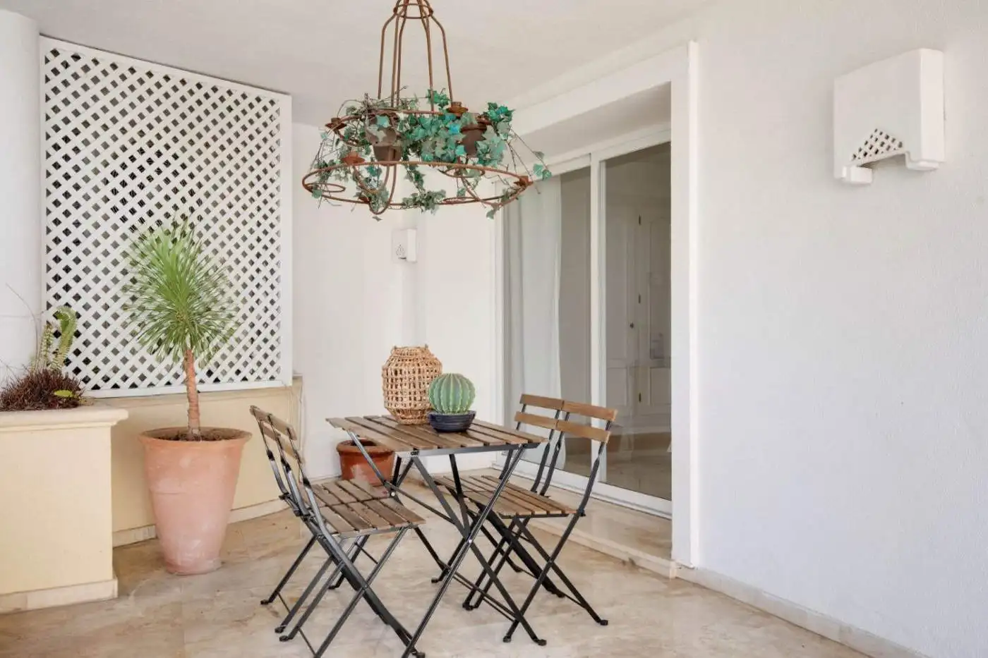 Balcony with outdoor seating and lush plant, perfect for relaxing and enjoying garden views.