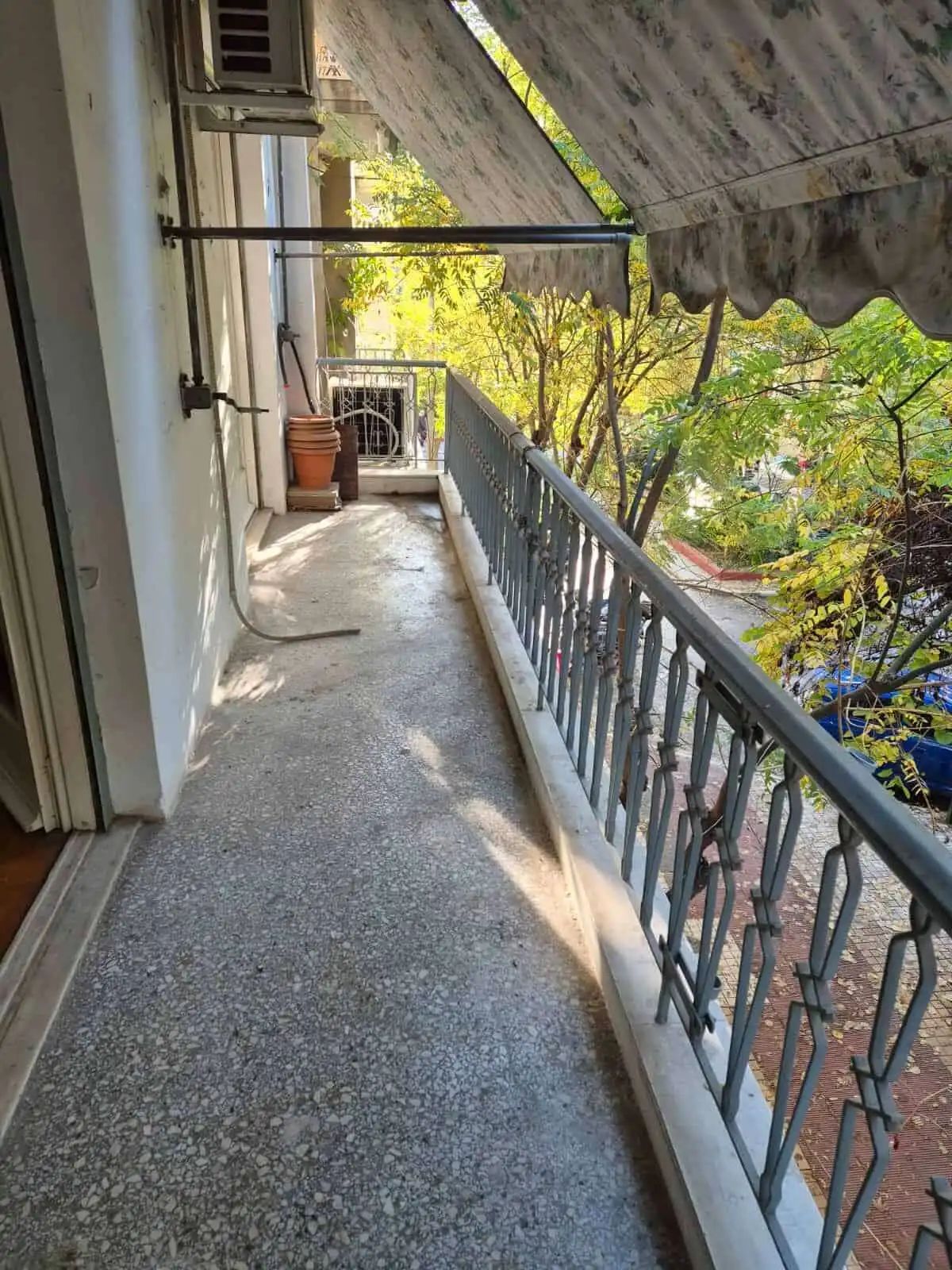 Balcony of a Kypseli Athens apartment with metal railing and outdoor space.