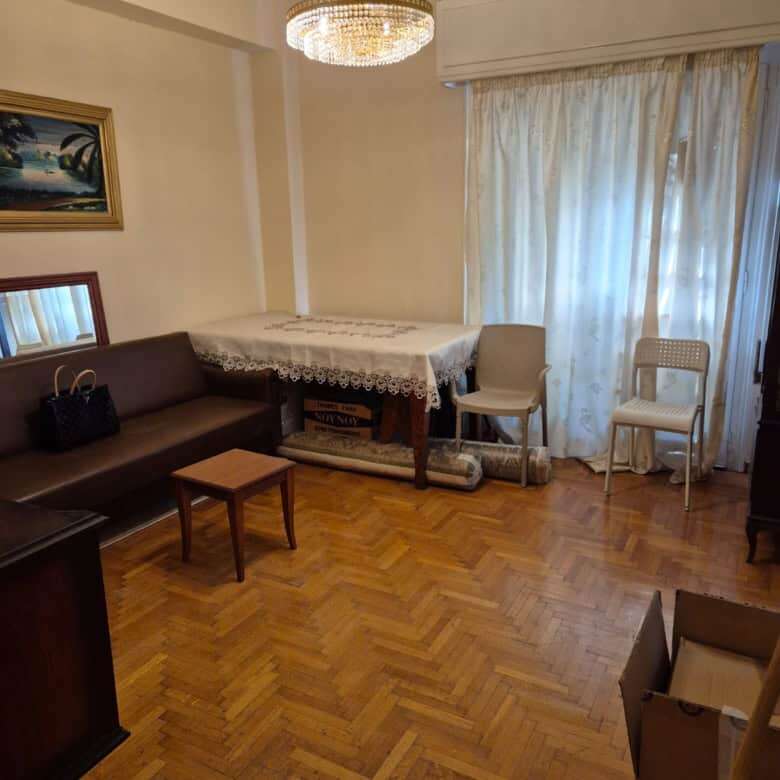 Bright living room in Athens apartment with wooden flooring and classic furniture.