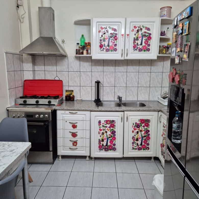 Kitchen with floral decorated cabinet doors and modern appliances.