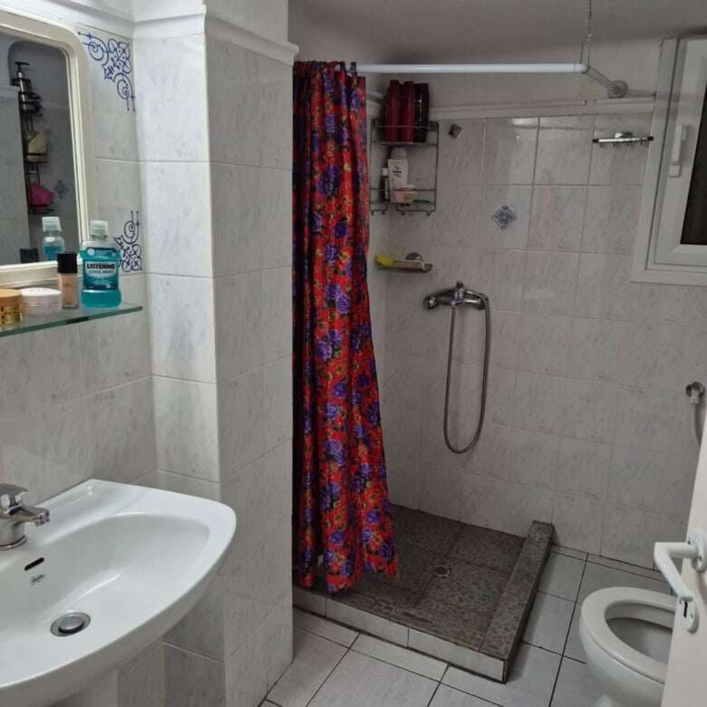 Bathroom with shower and basic amenities in a city apartment in Kypseli, Athens.