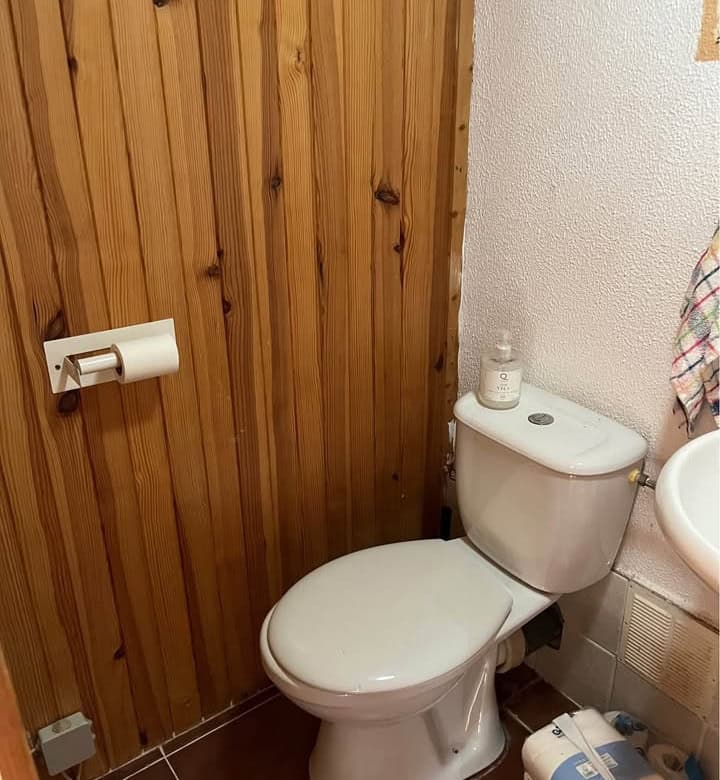 Comfortable bathroom with toilet and wooden wall paneling in a Spanish mobile home.
