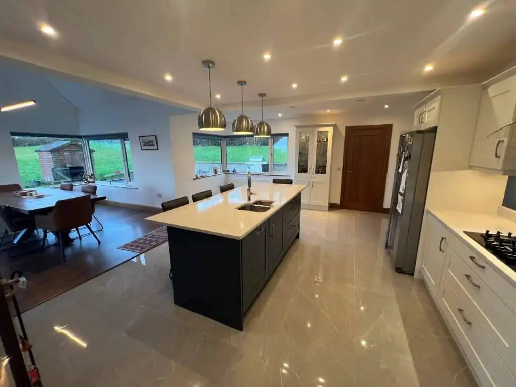 Spacious contemporary kitchen featuring a central island, sleek cabinetry, and large windows with sc.