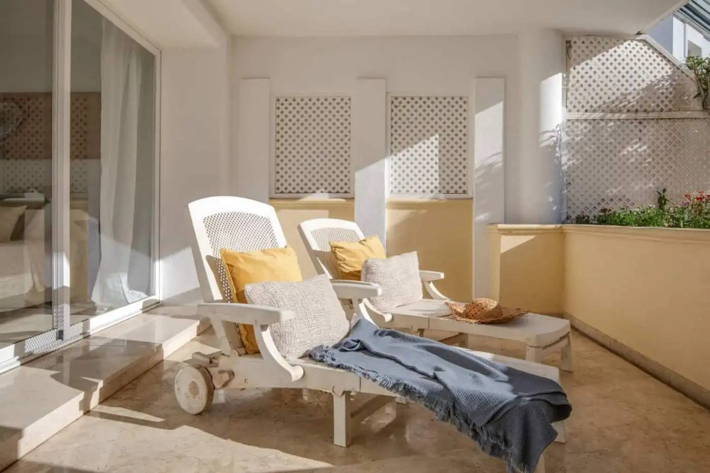 Beachfront balcony with lounge chairs and ocean view.
