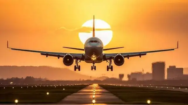 Commercial airplane taking off at sunset with vibrant sky.