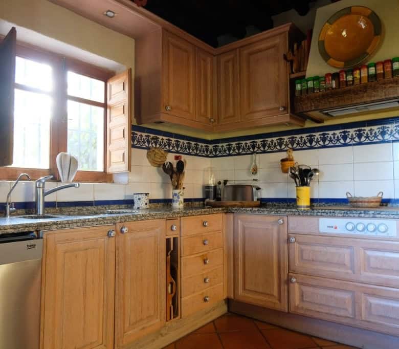 Cozy kitchen with wooden cabinets and traditional decor in La Casa de la Panzona finca, Estepona, Sp.