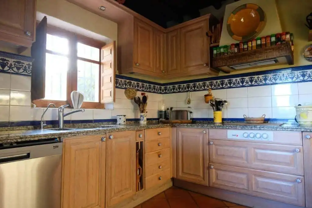 Cozy kitchen with wooden cabinets and traditional decor in La Casa de la Panzona finca, Estepona, Sp.