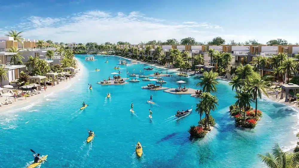 Scenic view of a luxury waterfront resort with boats, palm trees, and clear blue water.