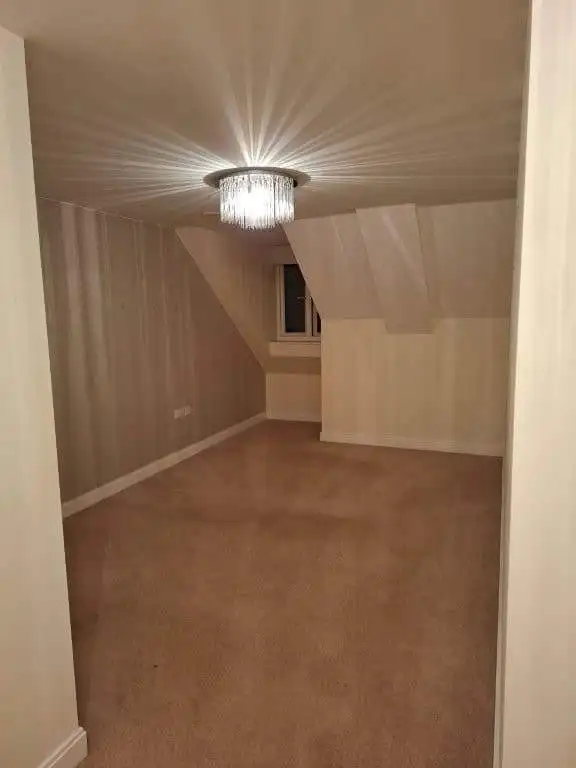Apartment interior with cozy bedroom space and elegant lighting fixture.