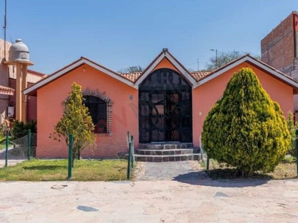 Beautiful countryside retreat featuring a pink house, lush greenery, and a welcoming entrance. Perfe.