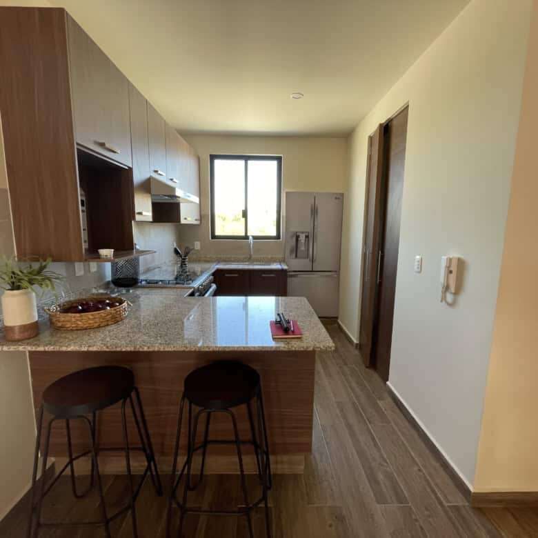 Interior view of a modern 2-bedroom rooftop home in San Miguel de Allende with kitchen and seating a.