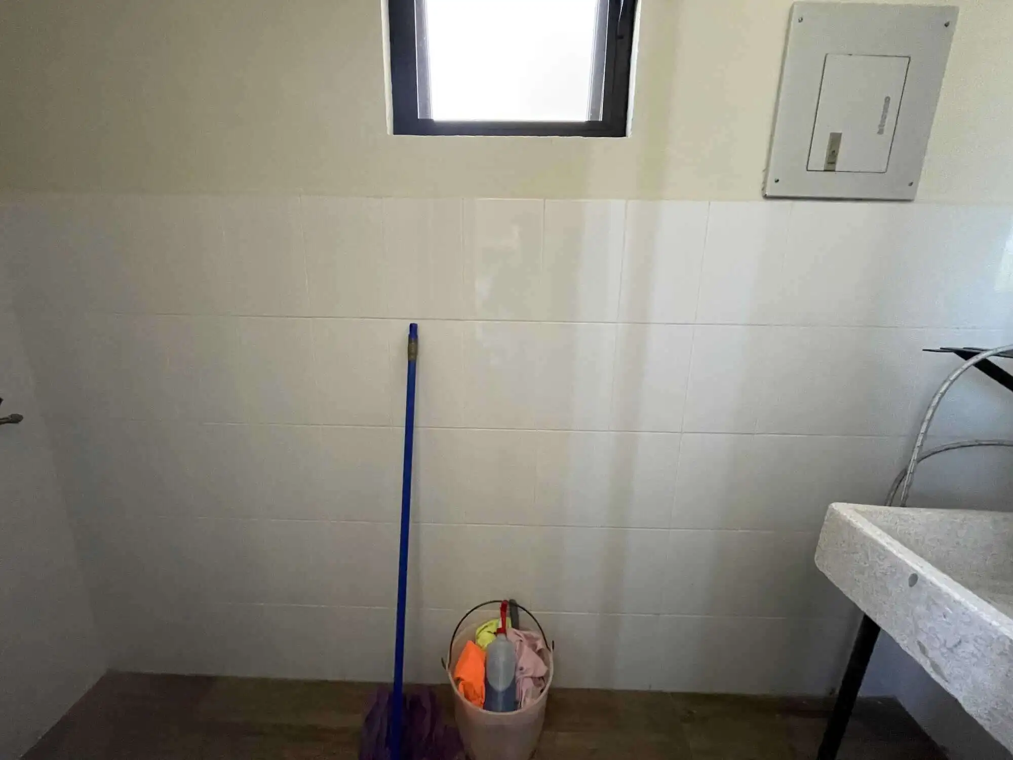 Interior view of a small laundry area in a rooftop home in San Miguel de Allende, featuring a window.