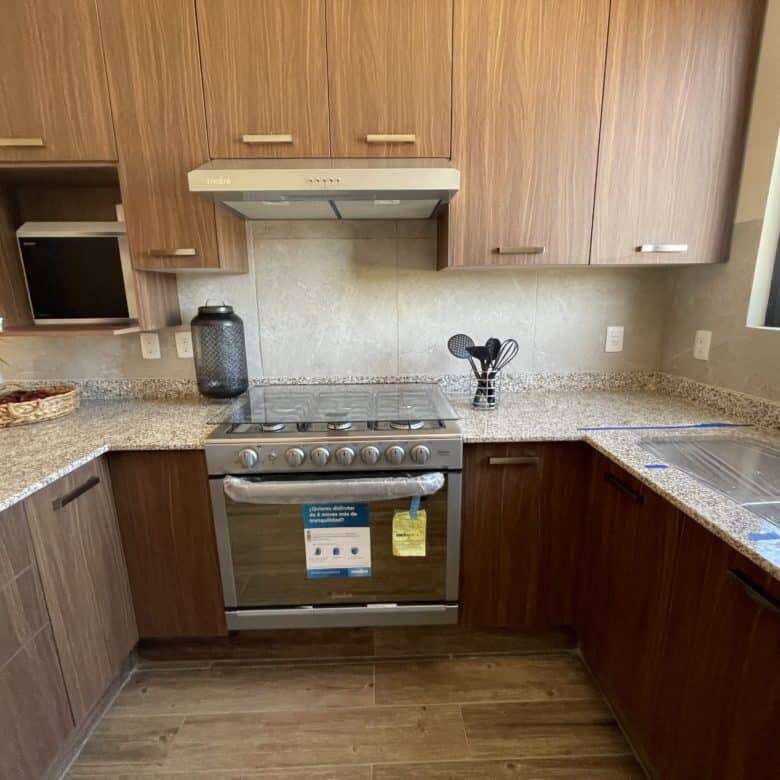 Cozy kitchen featuring wooden cabinetry and granite surfaces in a stylish San Miguel de Allende resi.