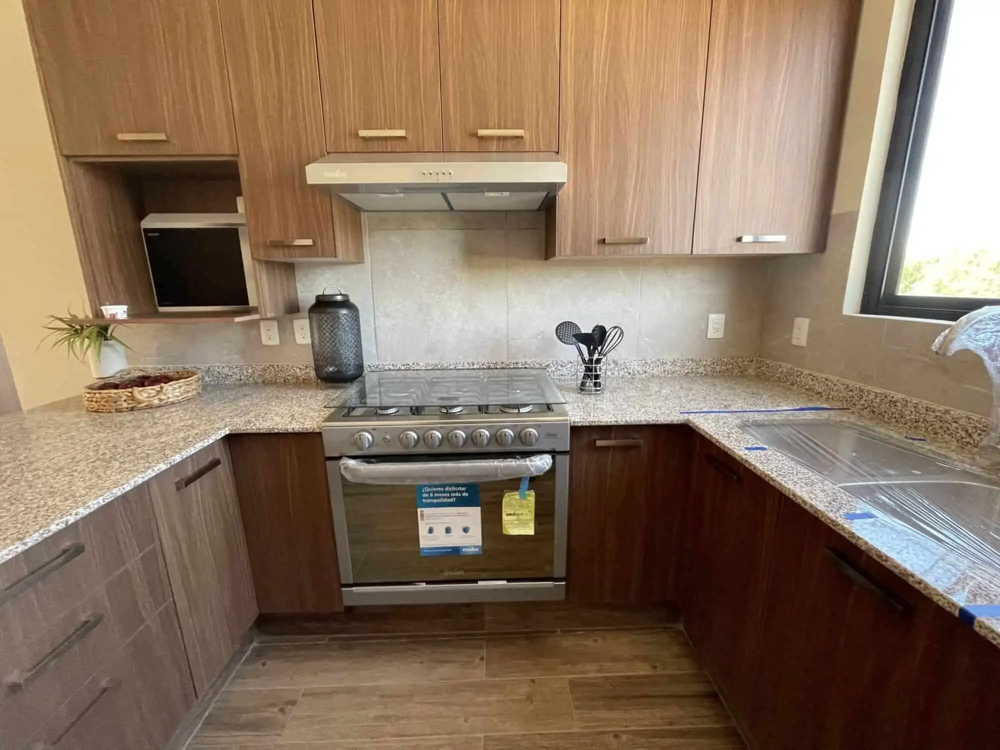 Cozy kitchen featuring wooden cabinetry and granite surfaces in a stylish San Miguel de Allende resi.