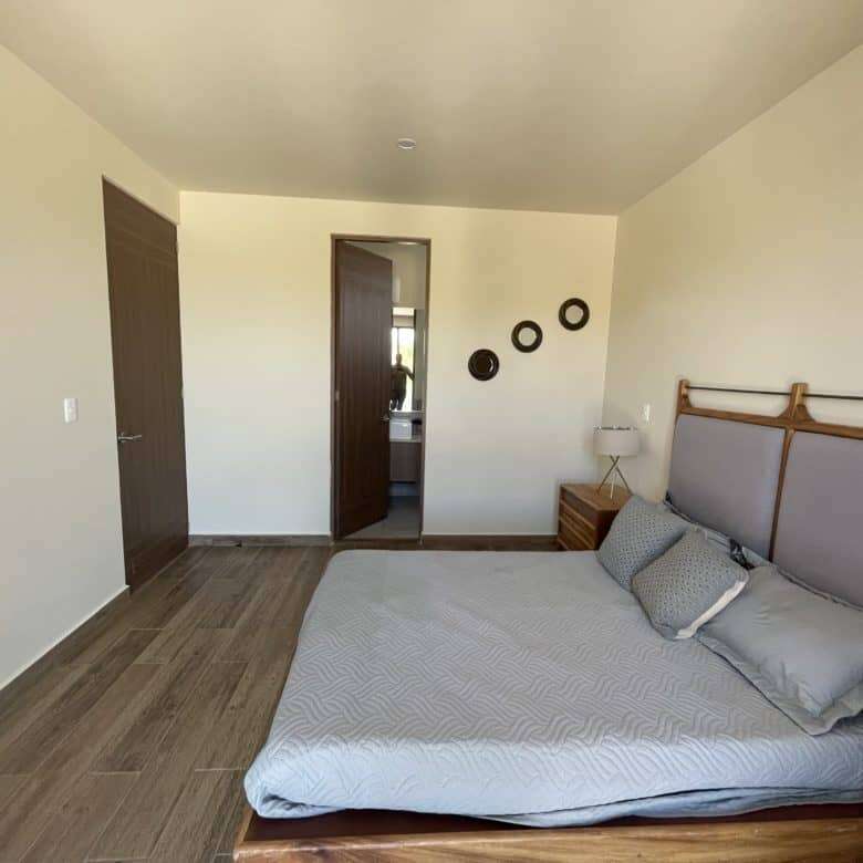 Modern bedroom with minimalist decor and wooden accents.