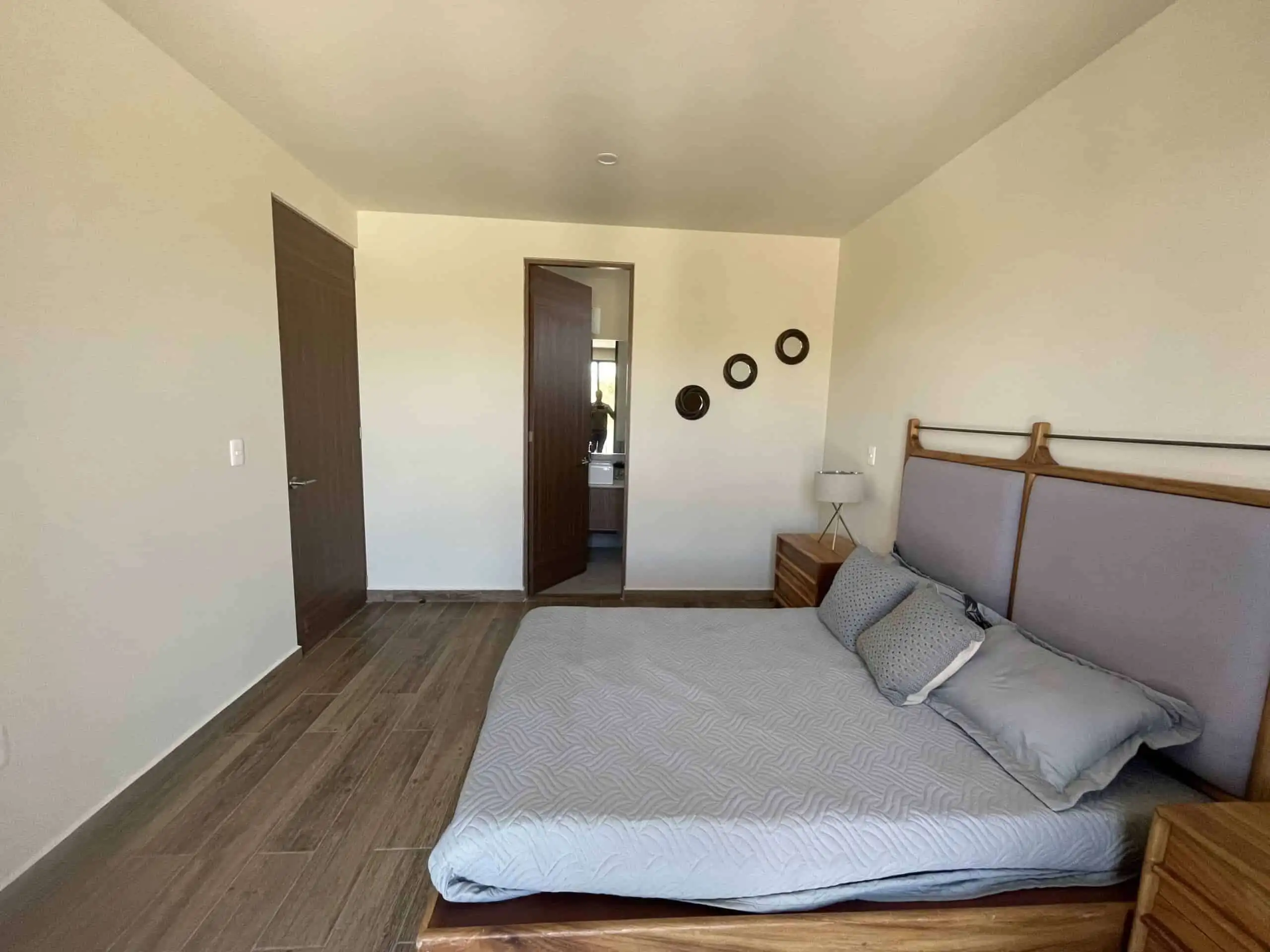 Modern bedroom with minimalist decor and wooden accents.