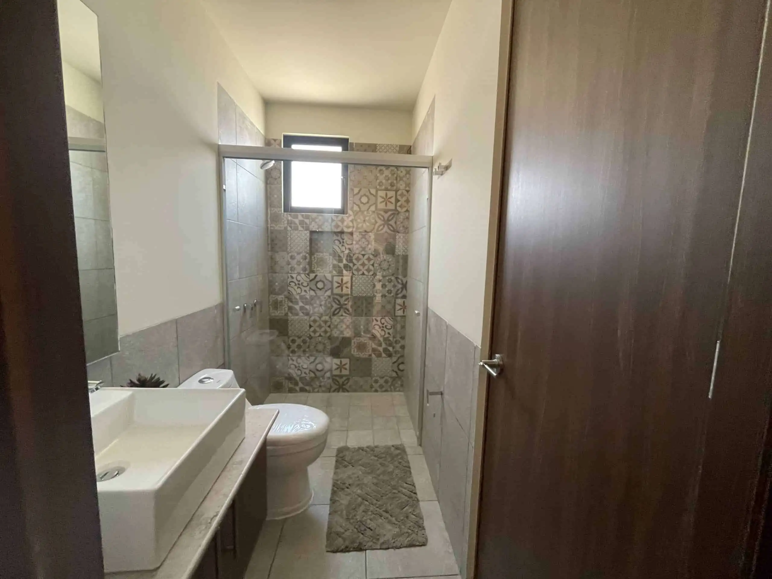 Bright bathroom with modern fixtures and decorative tile accents in San Miguel de Allende.