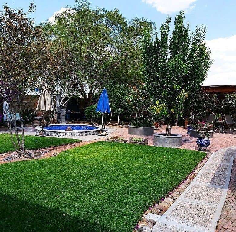 Beautiful outdoor garden with lush green lawn and mature trees in Rancho Los Labradores.
