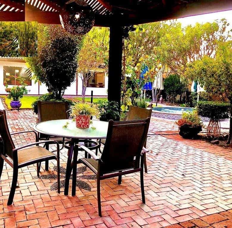 Outdoor patio with dining area and lush garden views.