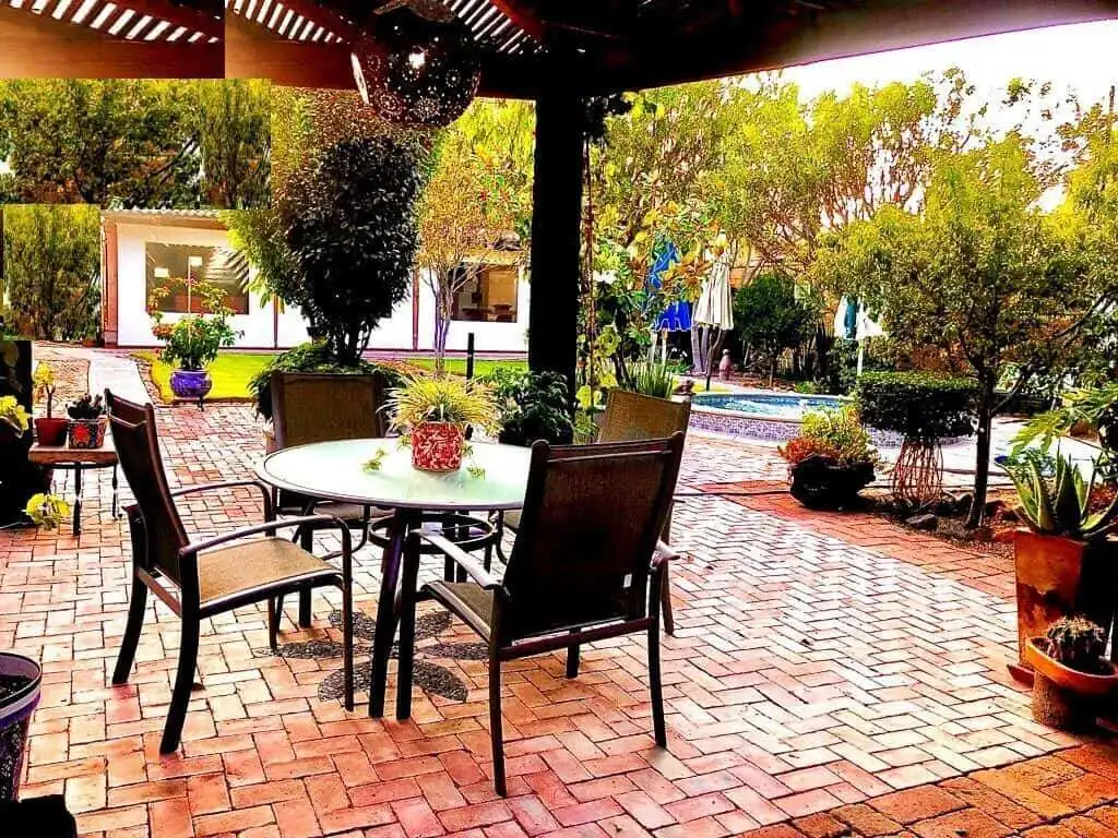 Outdoor patio with dining area and lush garden views.