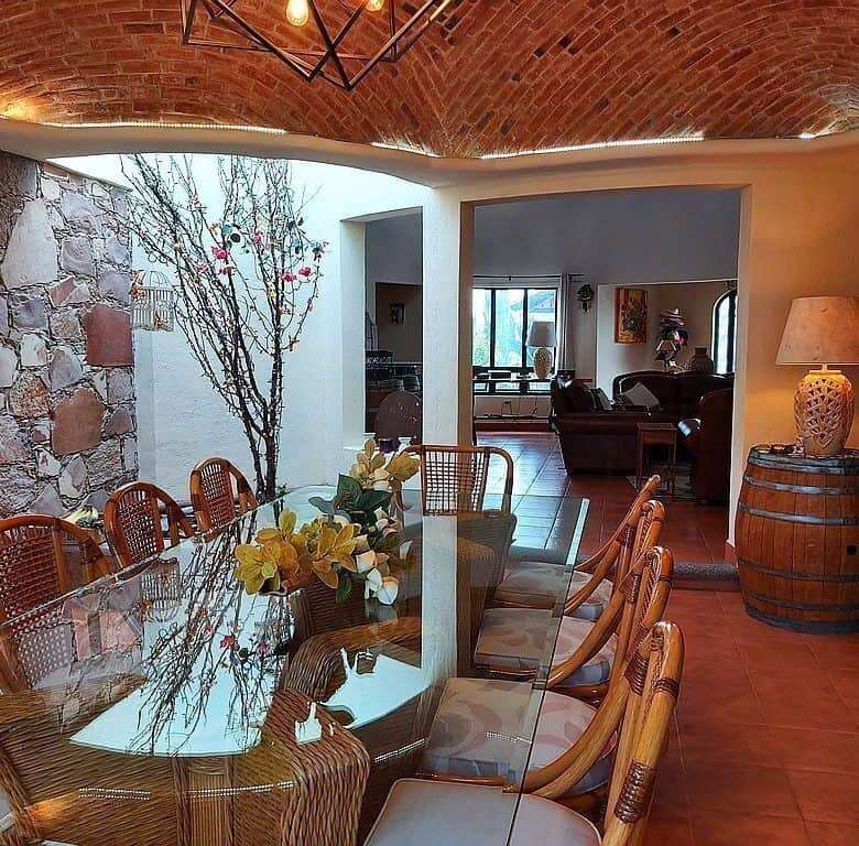 Elegant indoor dining area with rustic stone walls and a glass table.