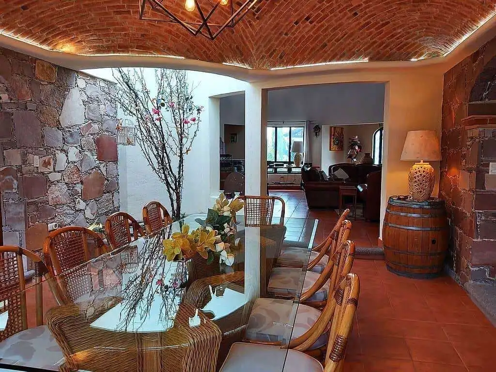 Elegant indoor dining area with rustic stone walls and a glass table.