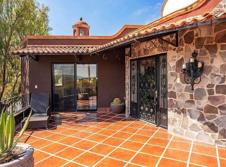 Elegant lakeside estate with stone accents and spacious terrace in Rancho Los Labradores.