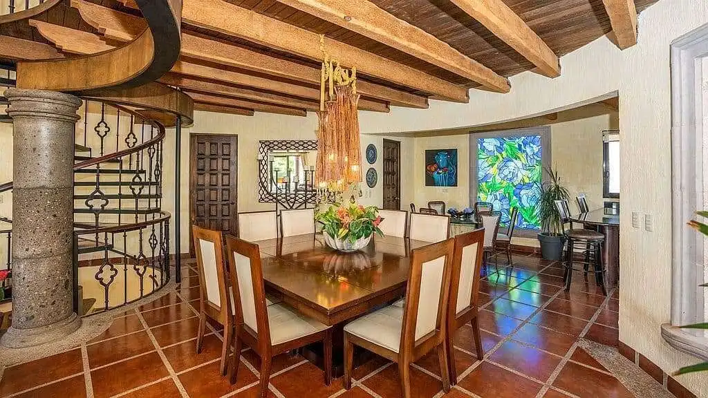 Luxury Spanish villa interior featuring a spiral staircase and elegant dining area.
