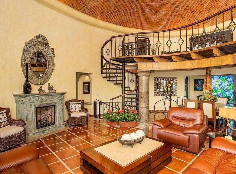 Elegant living room with spiral staircase, vintage furniture, and warm lighting for a cozy home atmo.
