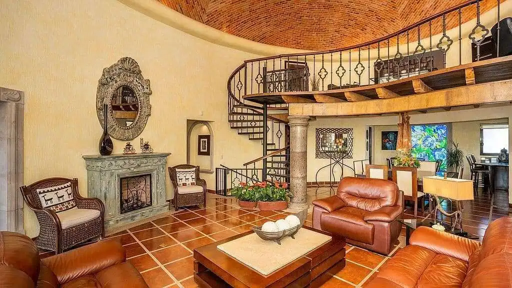 Elegant living room with spiral staircase, vintage furniture, and warm lighting for a cozy home atmo.
