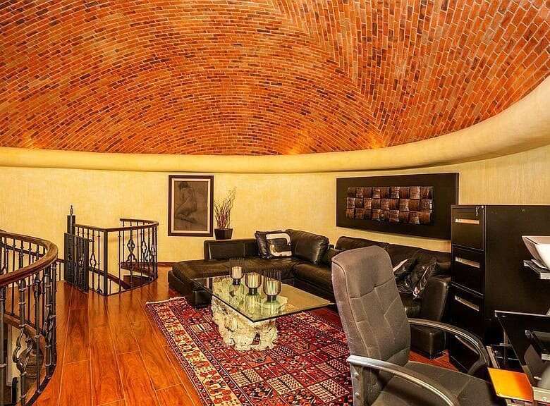 Spacious living room featuring a curved brick ceiling, comfortable sofa, and modern decor.