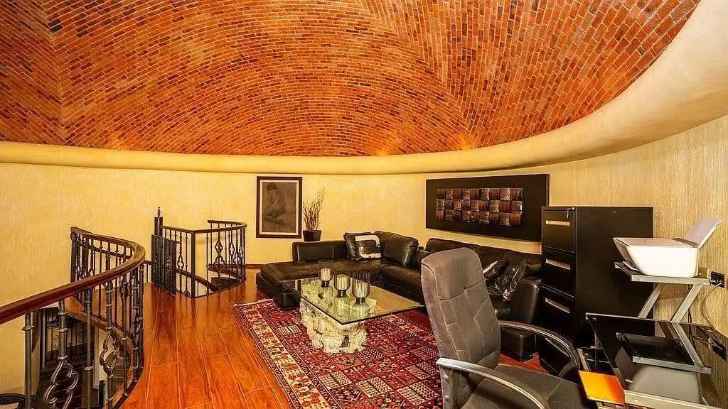 Spacious living room featuring a curved brick ceiling, comfortable sofa, and modern decor.