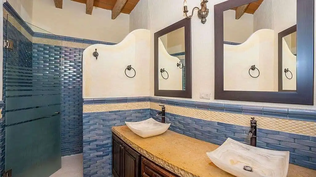 Elegant lakeside estate bathroom with dual vessel sinks and modern fixtures.