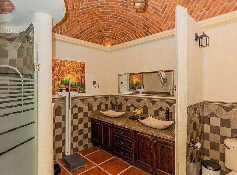 Elegant bathroom with dual sinks, modern fixtures, and decorative tile accents in a lakeside estate.