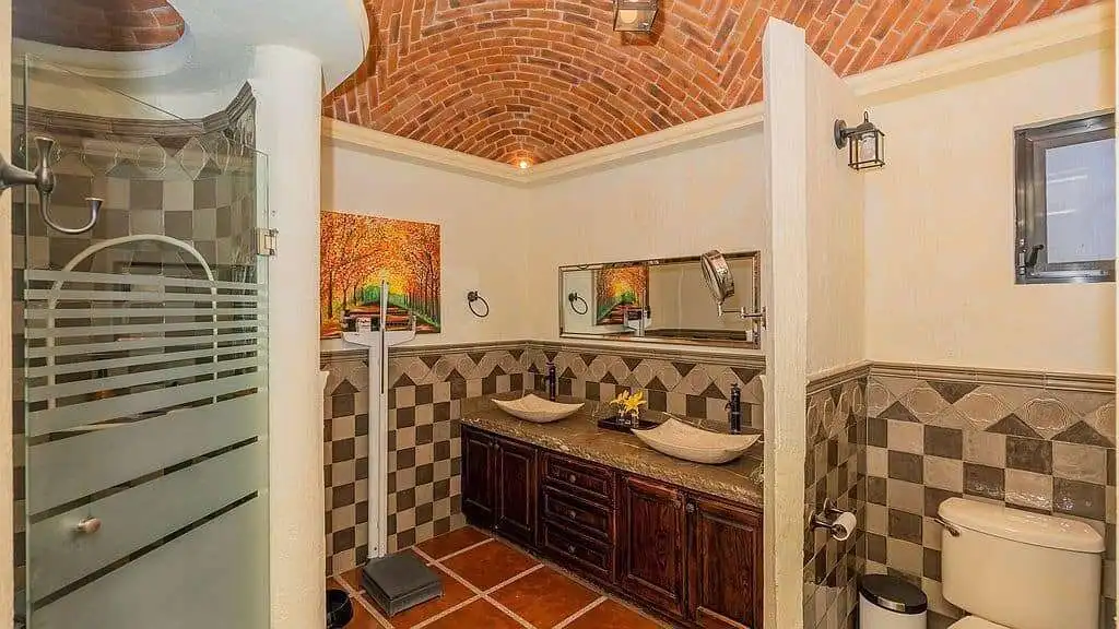 Elegant bathroom with dual sinks, modern fixtures, and decorative tile accents in a lakeside estate.