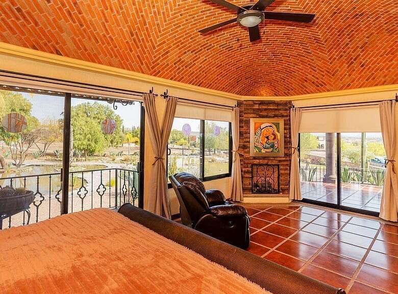 Spacious living room with large windows overlooking the lake in Rancho Los Labradores estate.