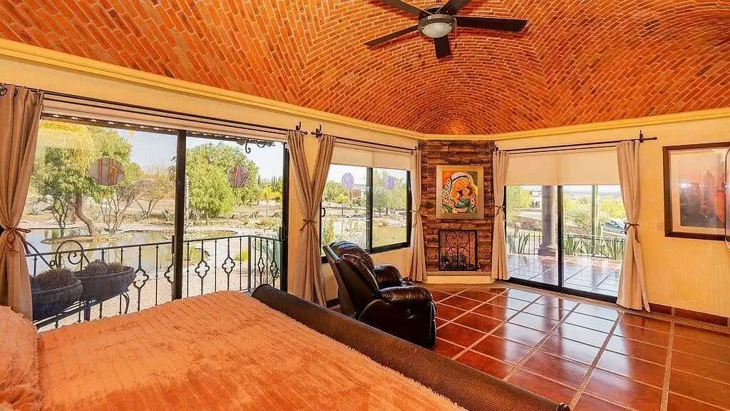Spacious living room with large windows overlooking the lake in Rancho Los Labradores estate.