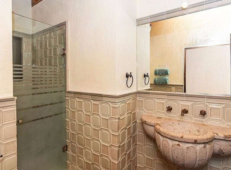 Bright bathroom with vintage sink and tiled walls in a lakeside estate.