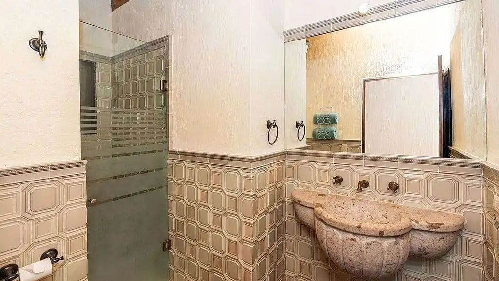 Bright bathroom with vintage sink and tiled walls in a lakeside estate.