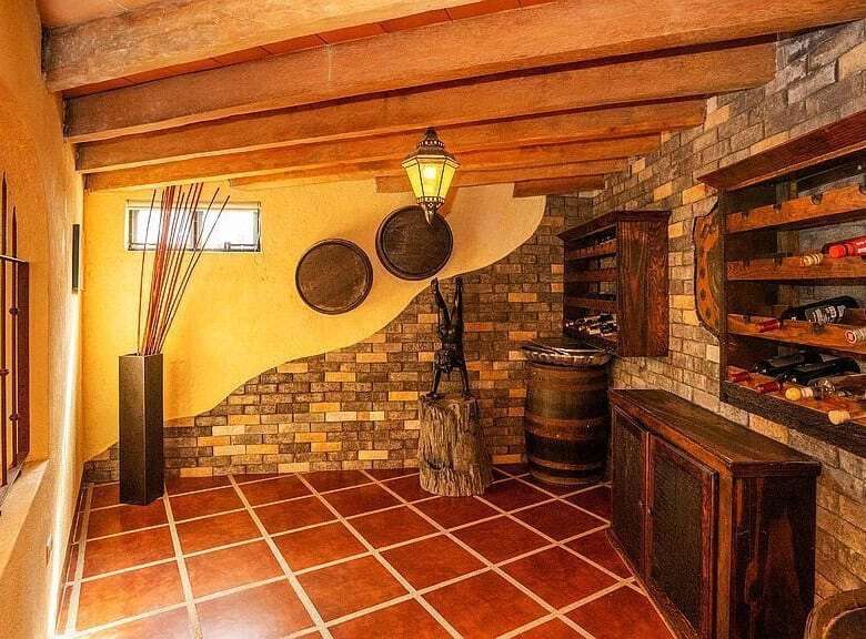 Elegant wine cellar with wooden racks and stone walls in a lakeside estate.