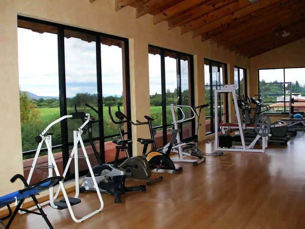 Indoor gym with exercise equipment overlooking scenic lake views.