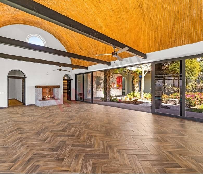 Bright and airy living space featuring expansive glass doors and a high wooden ceiling. Perfect for.