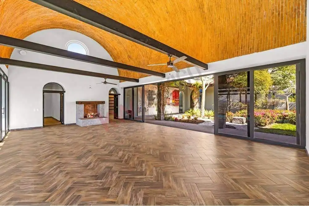 Bright and airy living space featuring expansive glass doors and a high wooden ceiling. Perfect for.